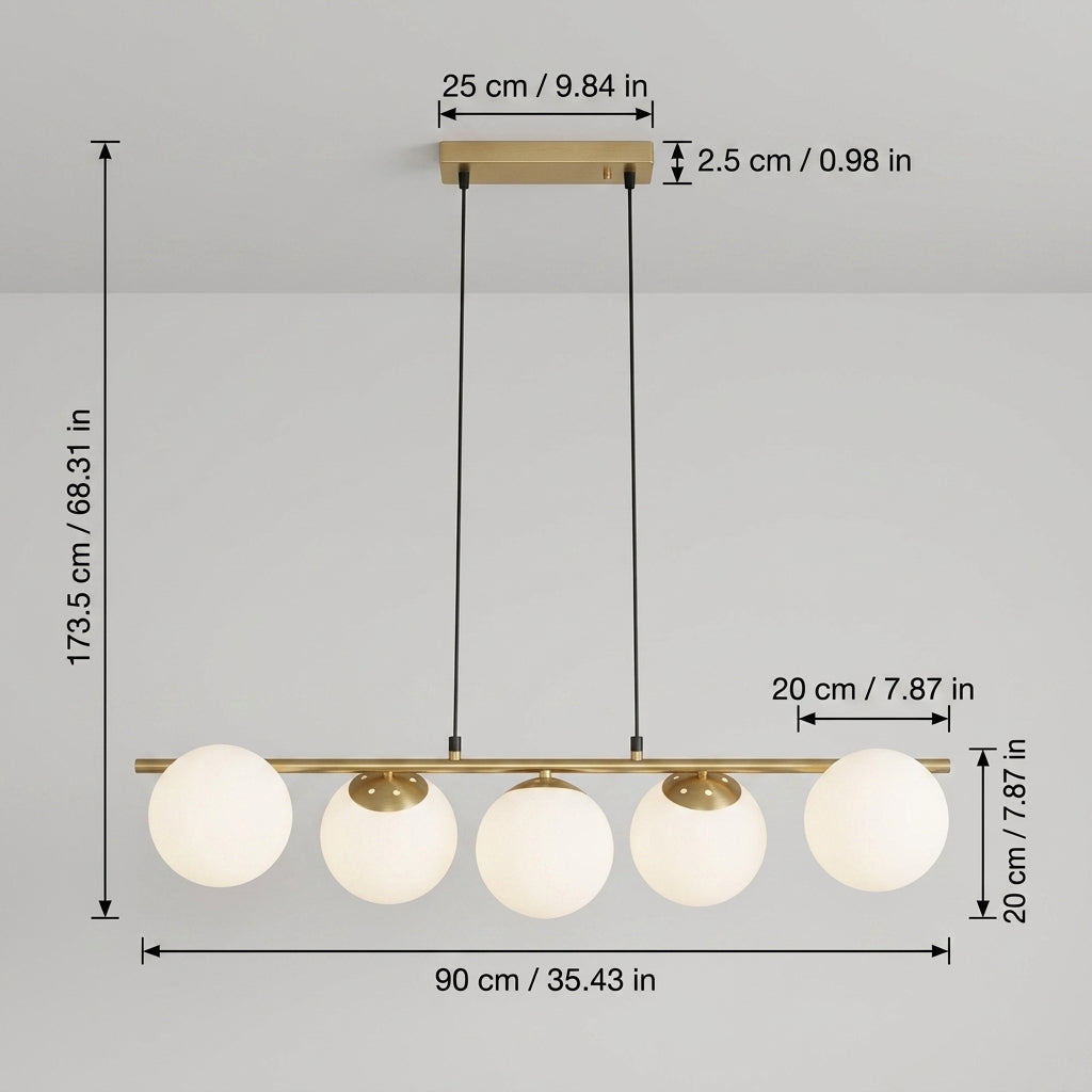 A 5-light linear ceiling pendant chandelier with white spherical glass globes and a brushed brass finish, shown with dimension callouts for height, width, and canopy spacing on a light gray background.