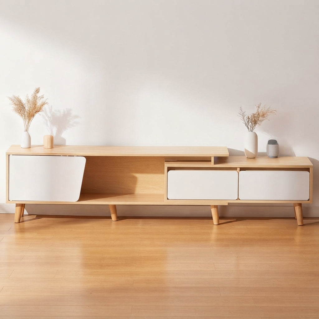 A modern light wood media console with white cabinet doors and tapered legs, styled in a minimalist room with a light wood floor and white wall.