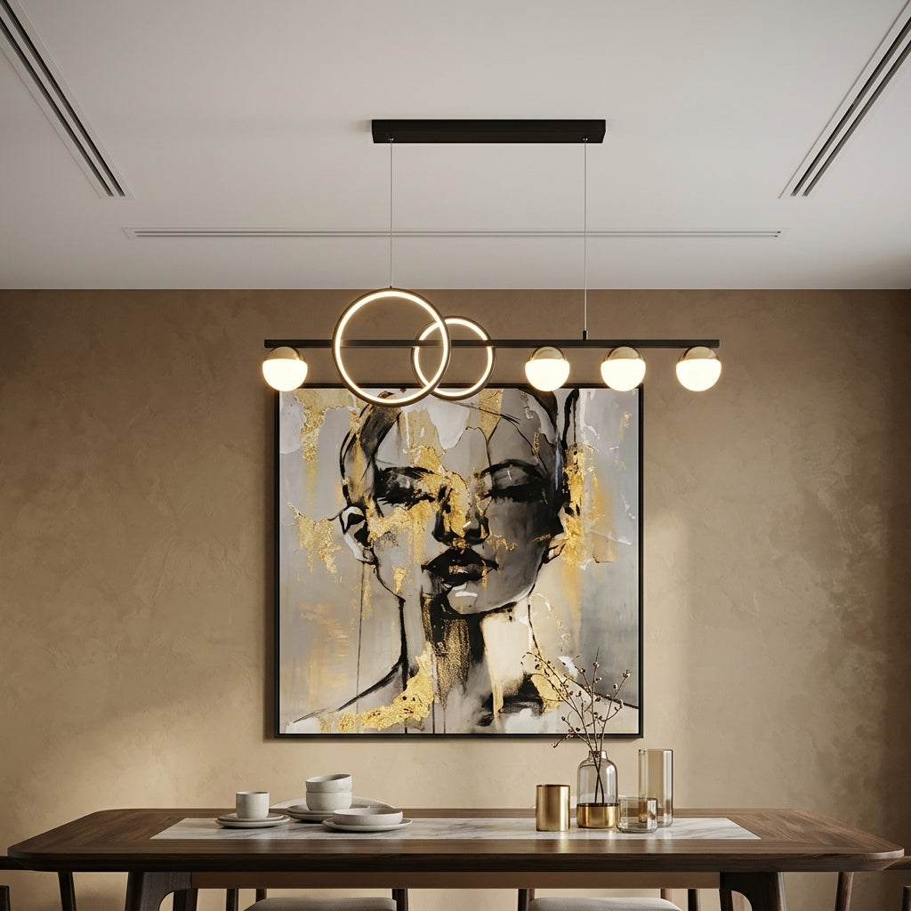 Modern dining room featuring a black linear chandelier with three overlapping circular gold-toned rings and four glowing globe bulbs, hanging above a dark wood table in front of a textured beige wall with a large abstract portrait painting.