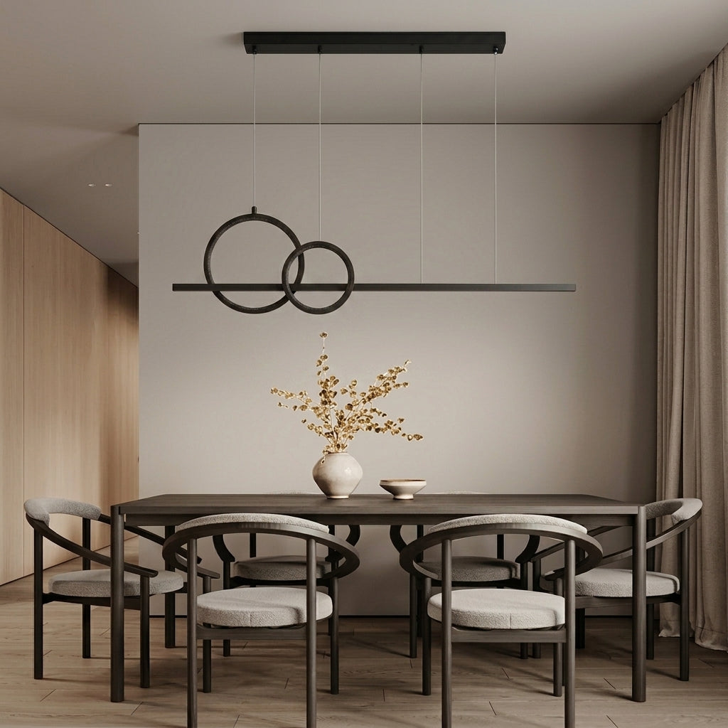 Modern dining room featuring a black linear pendant light with two interlocking circular rings hanging above a dark wood dining table and six matching chairs with light gray upholstered seats.