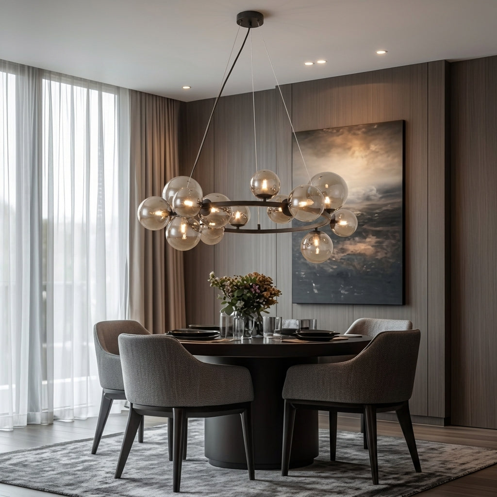 A modern multi-light cluster chandelier with clear glass globe bulbs hangs over a round dining table with gray upholstered chairs in a contemporary dining room.
