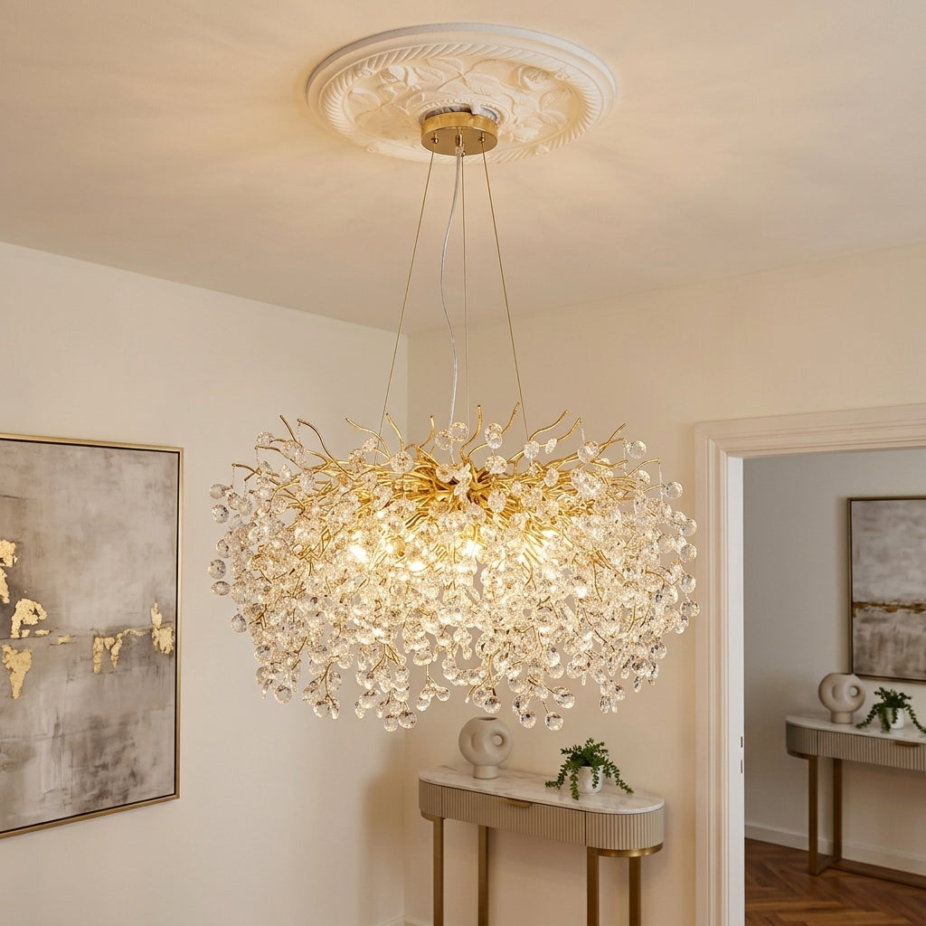 A large gold and crystal chandelier hanging from a decorative white ceiling medallion in a warm, elegant room with beige walls and a console table.