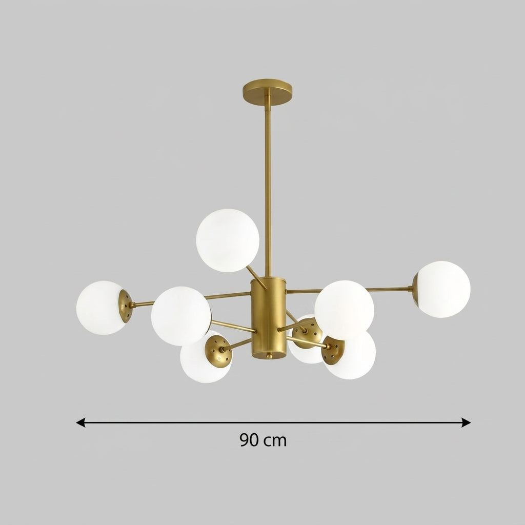 A modern multi-light chandelier with a brushed gold metal frame and multiple white spherical glass shades, shown against a solid gray background with a dimension line indicating a width of 90 cm.
