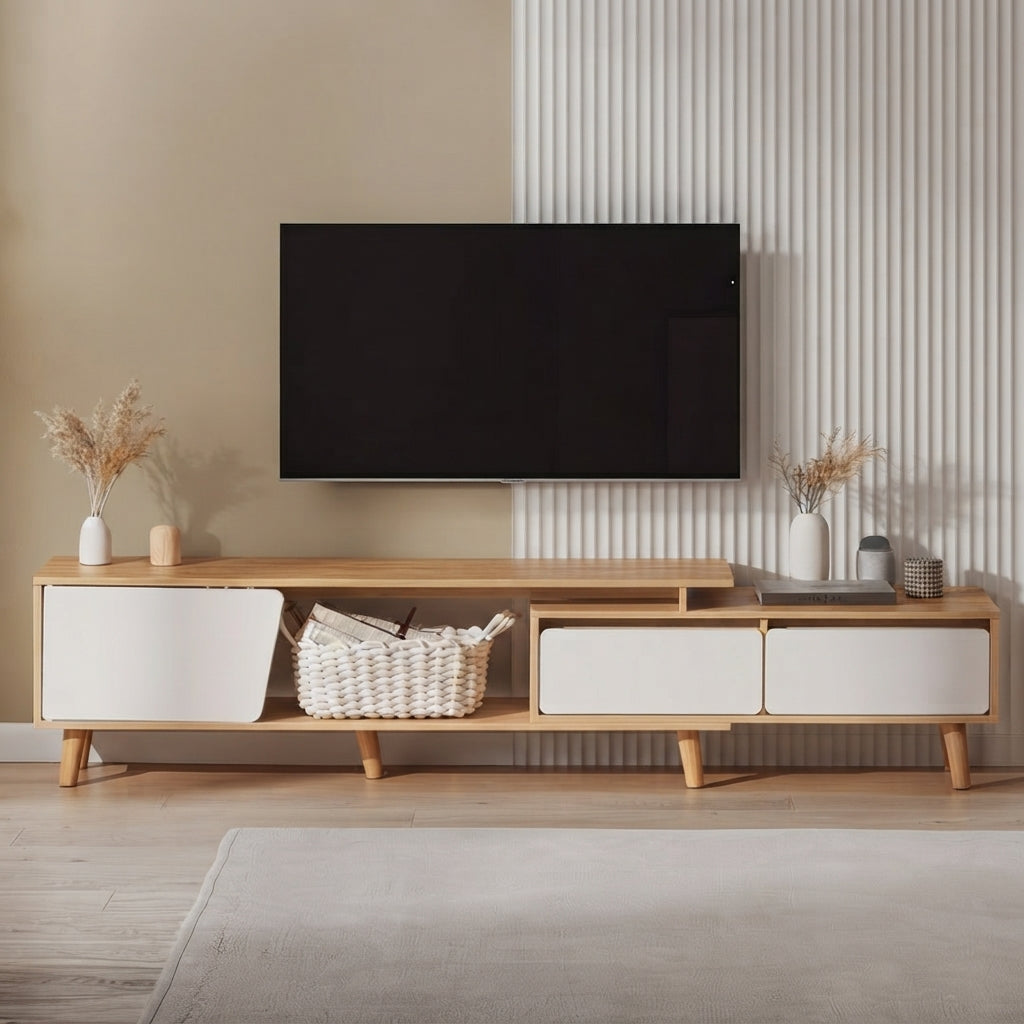 A mid-century modern wooden TV stand console with white drawer fronts and wooden legs, styled in a living room setting with a wall-mounted black TV, decorative vases, and a woven basket.