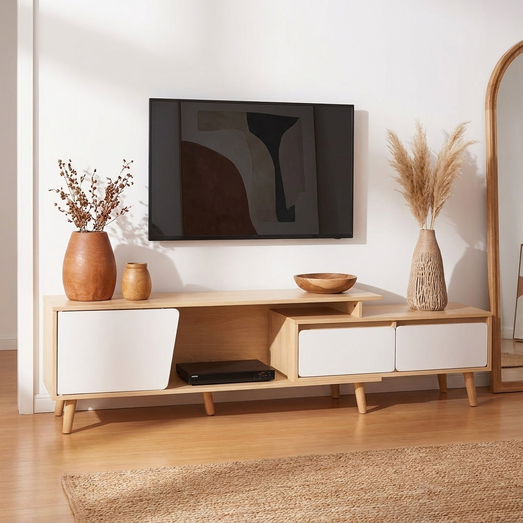 A mid-century modern wooden TV stand console with white drawer fronts, styled in a bright living room with a wall-mounted flat-screen TV, decorative vases, and a mirror.