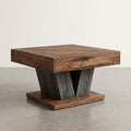A square wooden end table with a dark brown wood grain top and base, featuring a central V-shaped support made of weathered gray wood, set on a concrete floor against a neutral off-white wall.