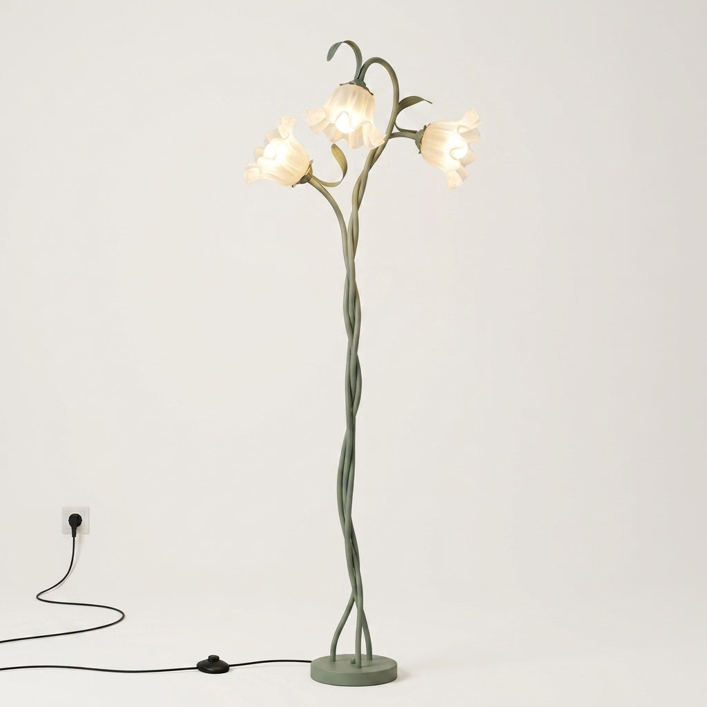 A whimsical floor lamp designed like a twisted tree trunk with three glowing bell-shaped flowers on a light gray background.