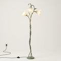 A whimsical floor lamp designed like a twisted tree trunk with three glowing bell-shaped flowers on a light gray background.